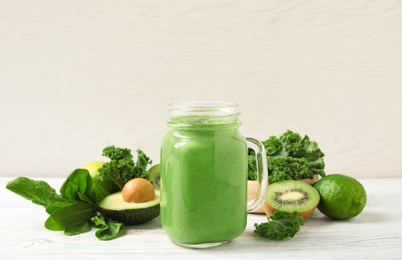 Photo of Tasty fresh kale smoothie on white wooden table