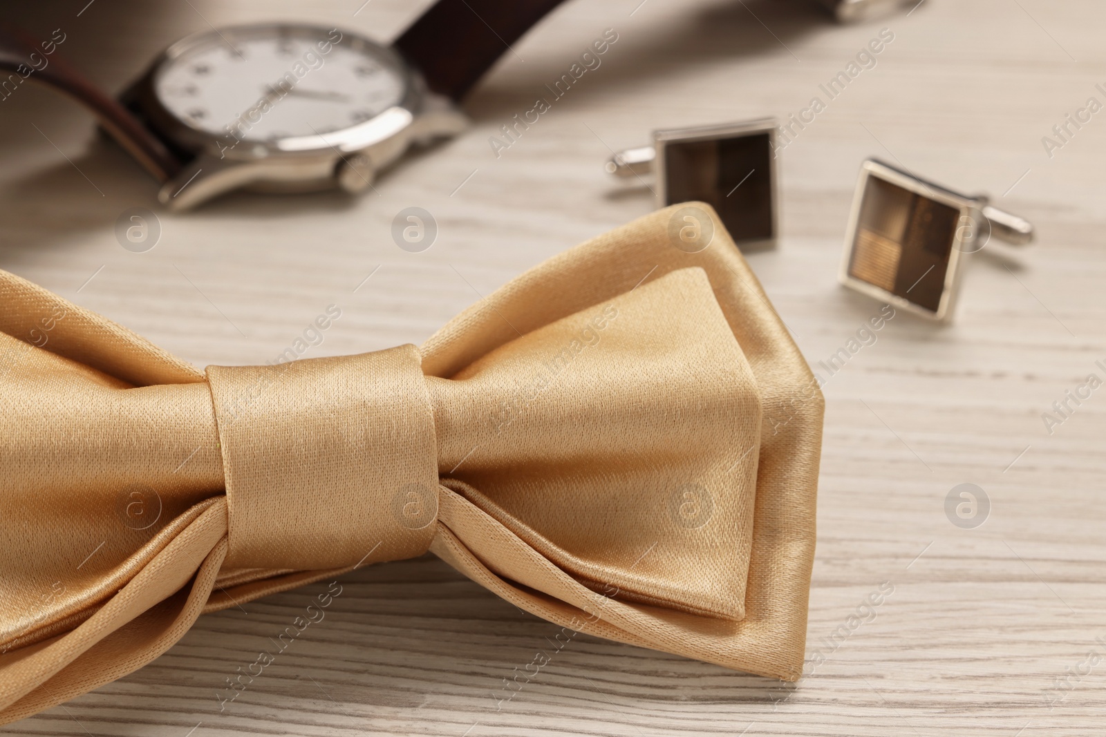 Photo of Stylish beige bow tie on white wooden background, closeup
