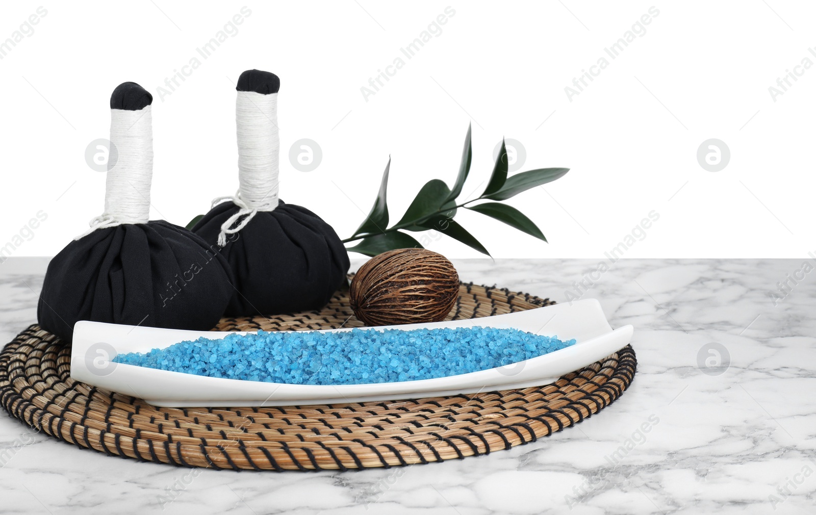 Photo of Composition with blue sea salt and herbal bags on marble table against white background