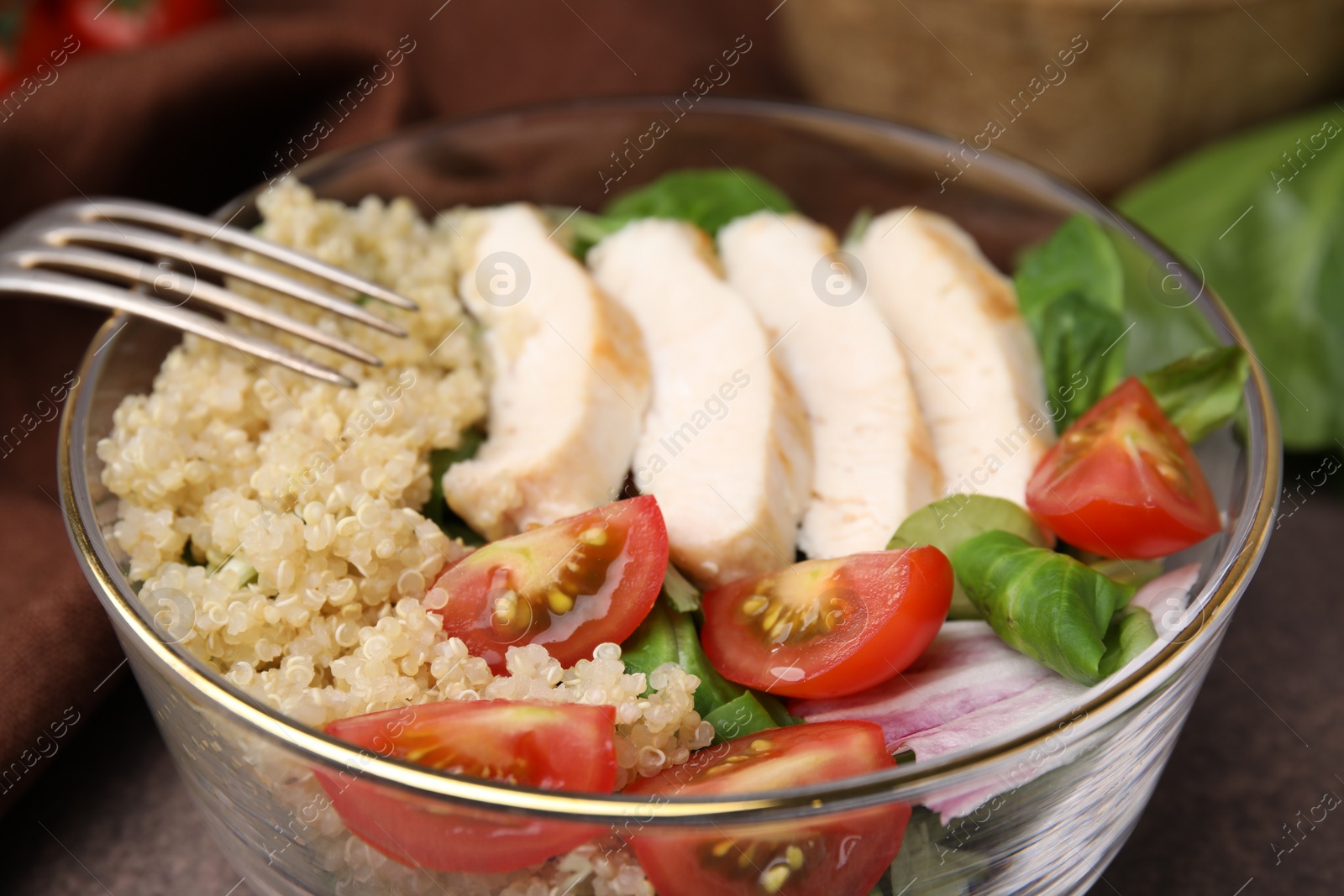 Photo of Delicious quinoa salad with chicken and cherry tomatoes served on table, closeup