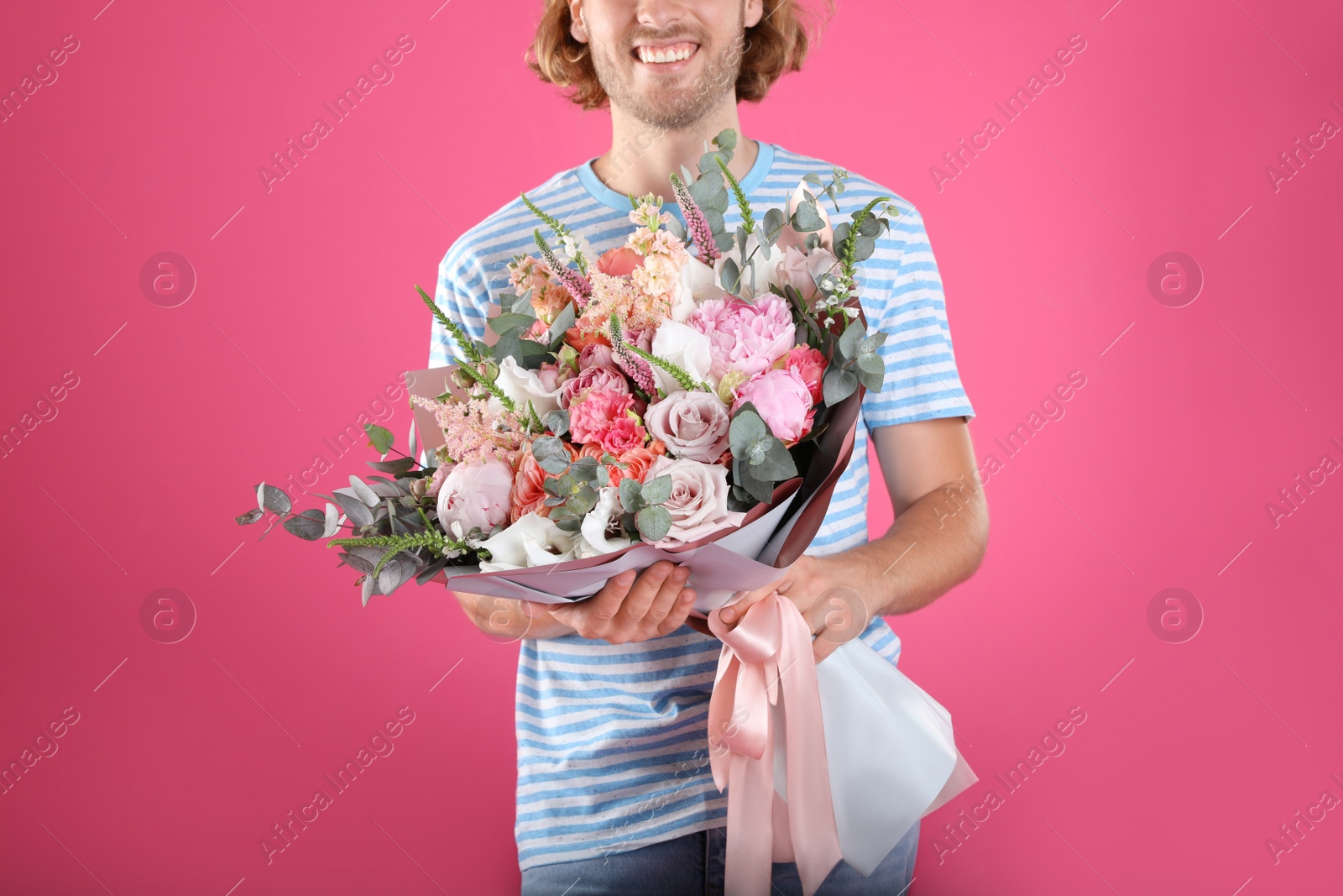 Photo of Man holding beautiful flower bouquet on pink background, closeup view