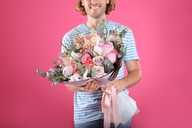 Man holding beautiful flower bouquet on pink background, closeup view