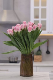 Photo of Beautiful bouquet of fresh pink tulips on table in kitchen