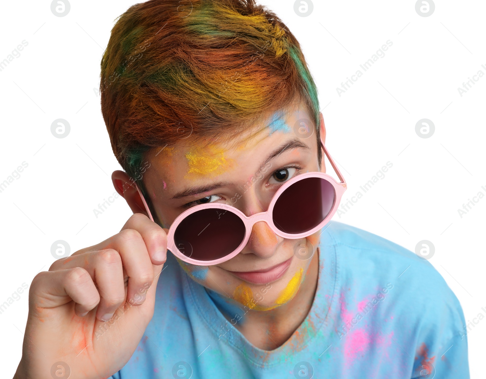 Photo of Teen boy covered with colorful powder dyes on white background. Holi festival celebration