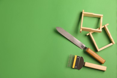Photo of Beekeeping tools on green background, flat lay. Space for text