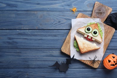 Cute monster sandwich served on blue wooden table, flat lay with space for text. Halloween party food