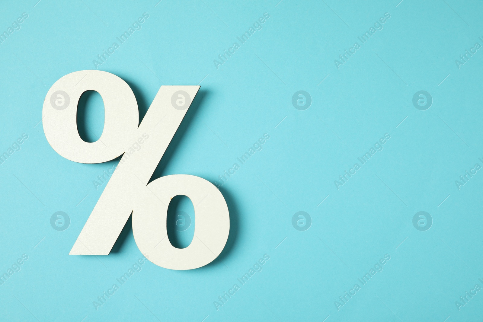 Photo of White percent sign on light blue background, top view. Space for text