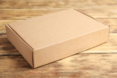 Closed cardboard box on brown wooden table