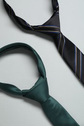 Two neckties on light background, top view