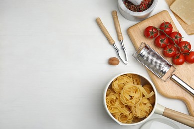 Cooking utensils and ingredients on white wooden table, flat lay. Space for text