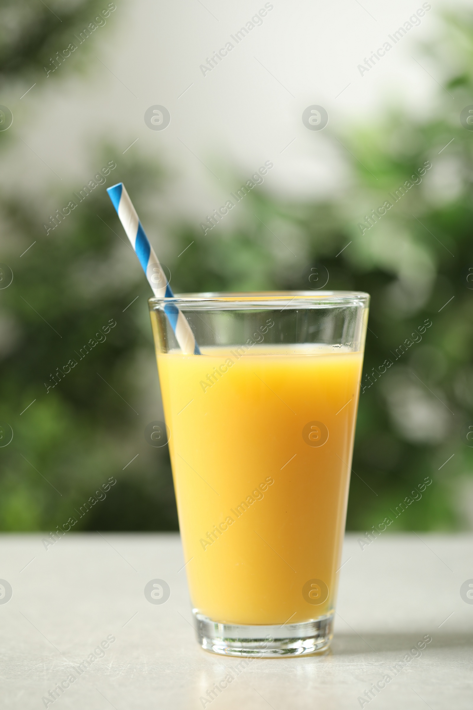 Photo of Glass of orange juice on light table