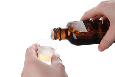 Photo of Woman pouring syrup into measuring cup from bottle isolated on white, closeup. Cough and cold medicine