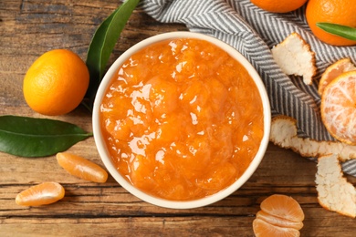 Flat lay composition with tasty tangerine jam on wooden table