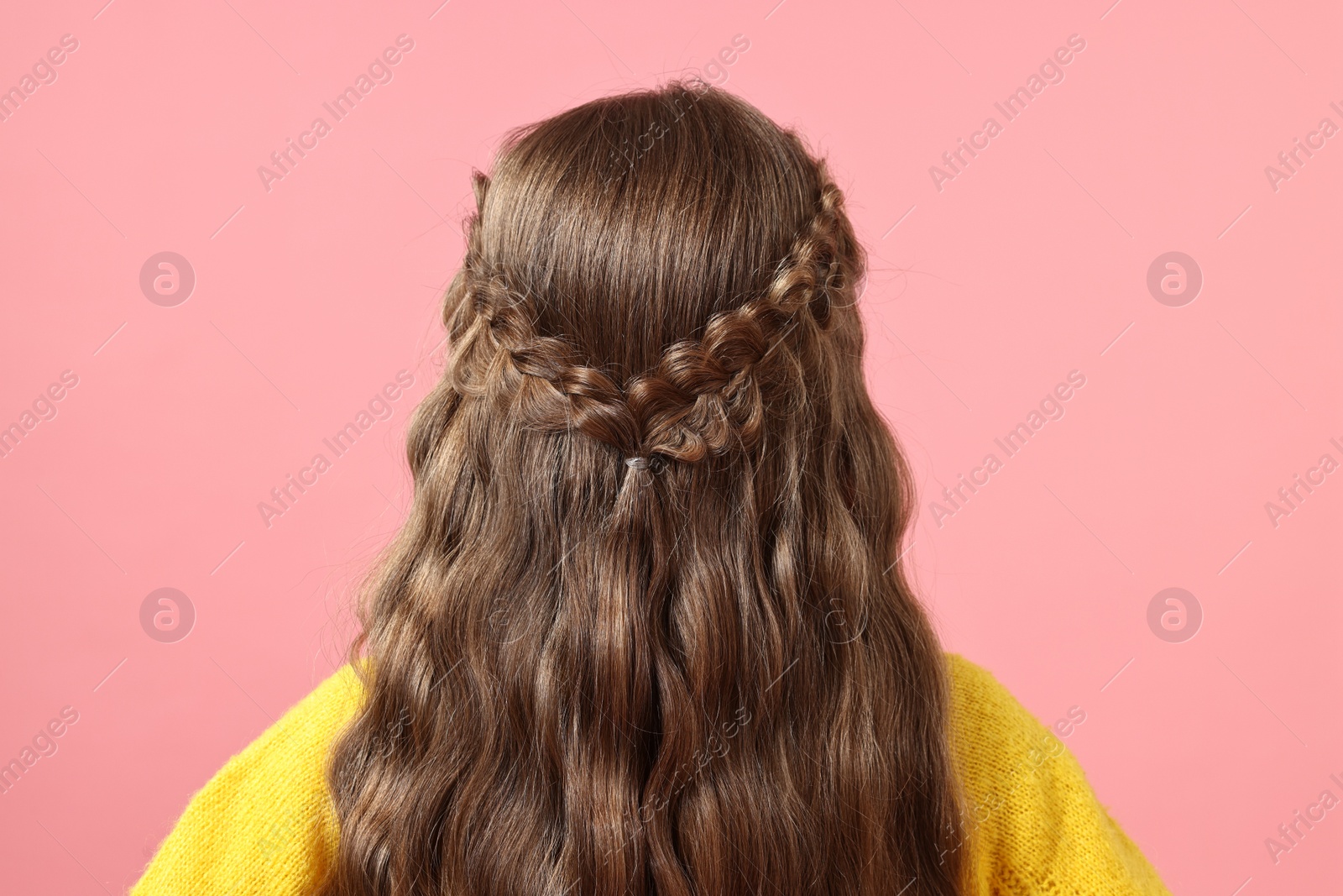 Photo of Little girl with braided hair on pink background, back view