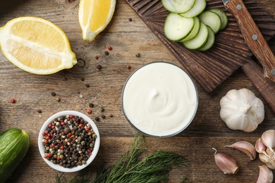 Photo of Flat lay composition with cucumber sauce and ingredients on wooden background