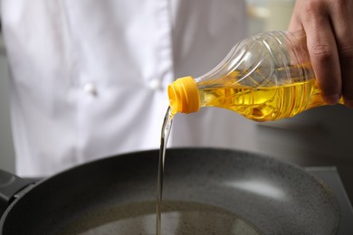 Man pouring cooking oil from bottle into frying pan, closeup