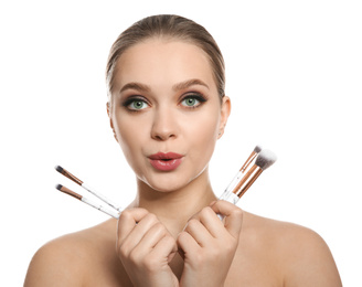 Beautiful woman with makeup brushes on white background