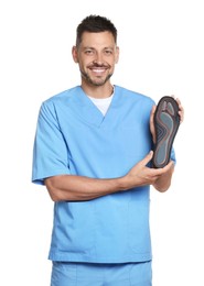 Photo of Handsome male orthopedist showing insole on white background