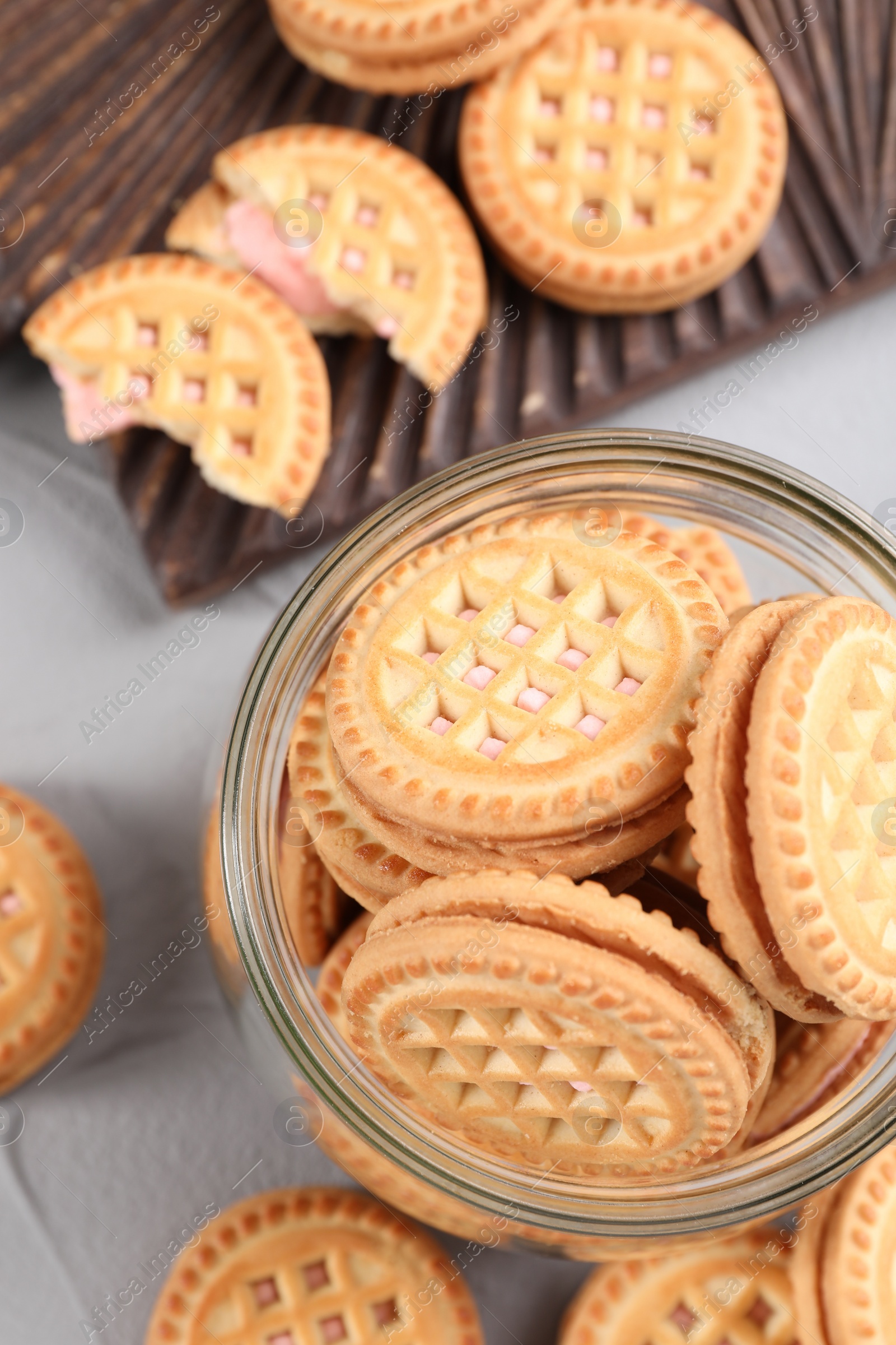 Photo of Tasty sandwich cookies with cream on light grey table, flat lay