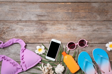 Photo of Flat lay composition with beach objects and mobile phone on wooden background