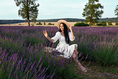 Photo of Beautiful young woman sitting in lavender field