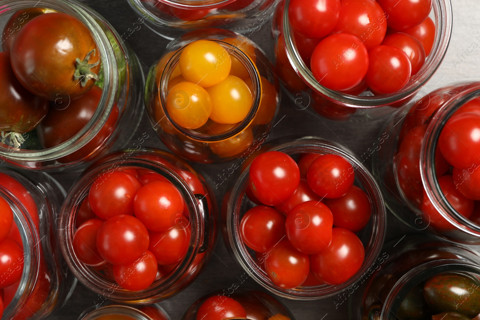 Photo of Pickling jars with fresh tomatoes, flat lay