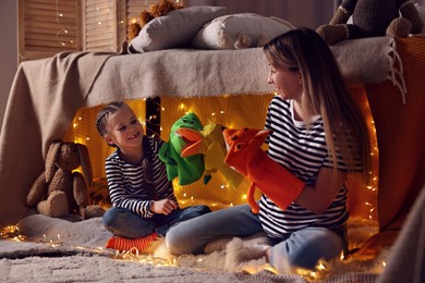 Photo of Mother and her daughter playing with toys in play tent at home