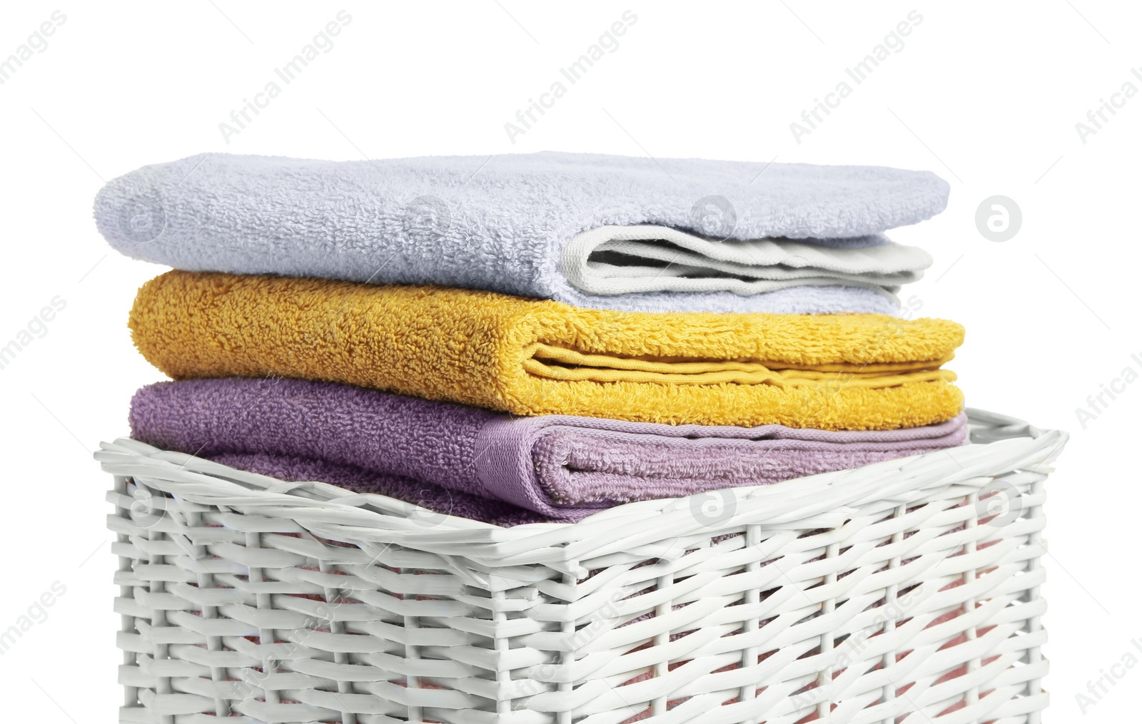 Photo of Wicker laundry basket with folded towels isolated on white