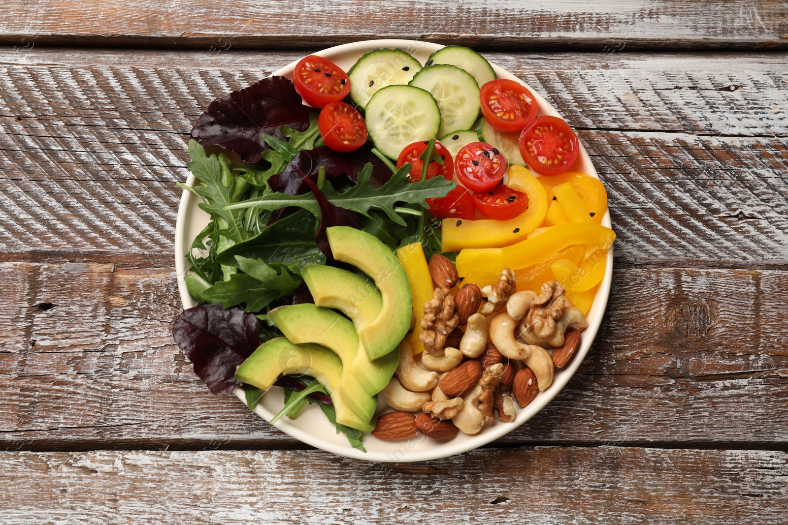 Photo of Balanced diet and vegetarian foods. Plate with different delicious products on wooden table, top view