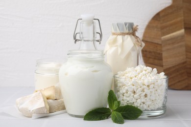 Photo of Different dairy products and mint on white table