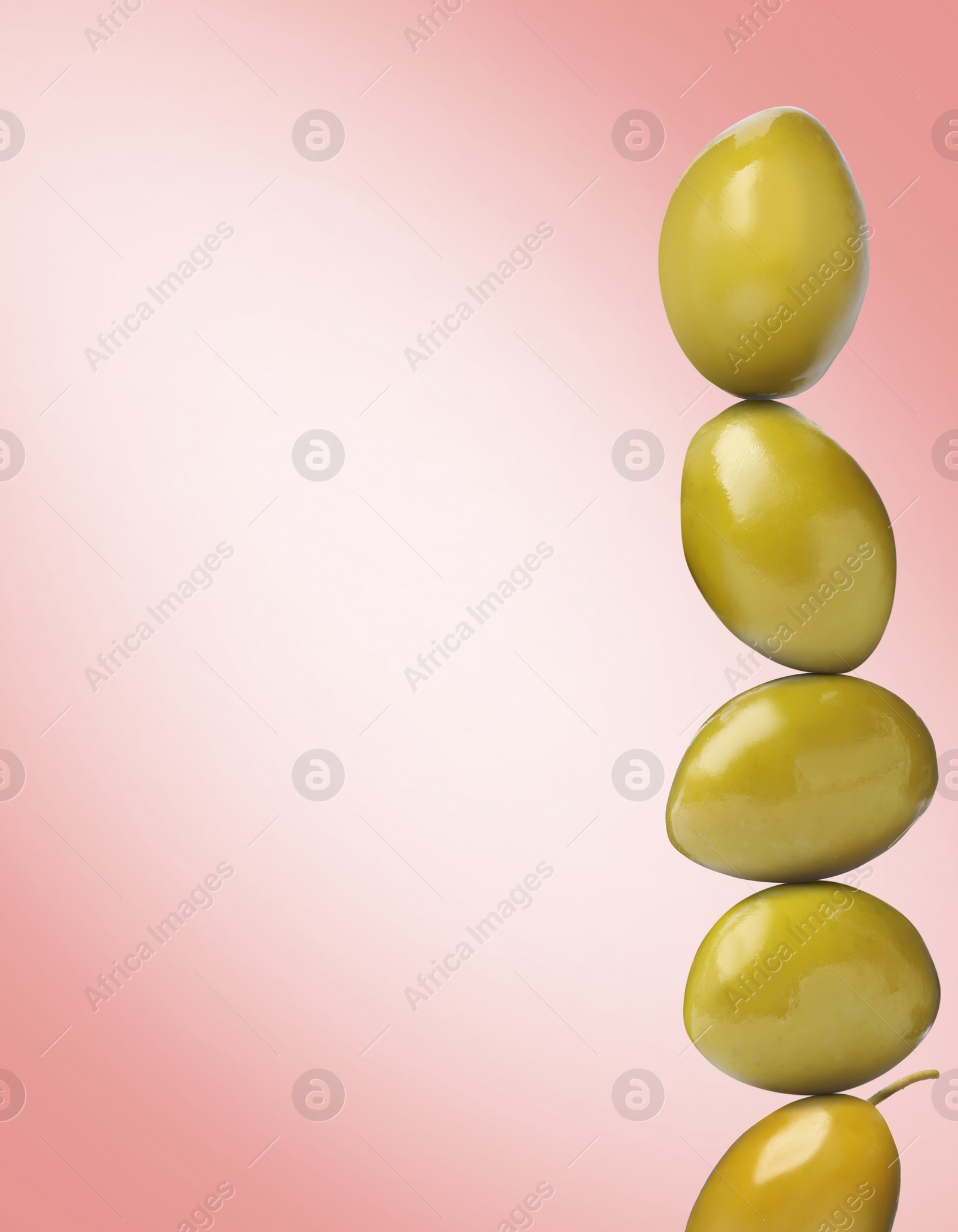 Image of Stack of whole olives on pink gradient background, space for text