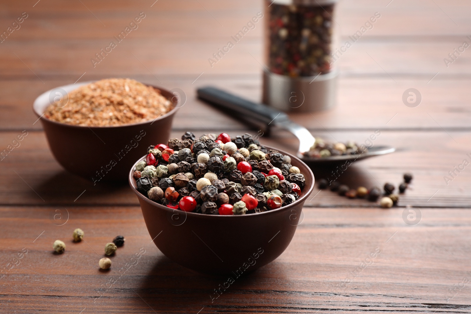 Photo of Bowls with mixed corns and powdered pepper on wooden table, space for text