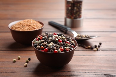 Bowls with mixed corns and powdered pepper on wooden table, space for text