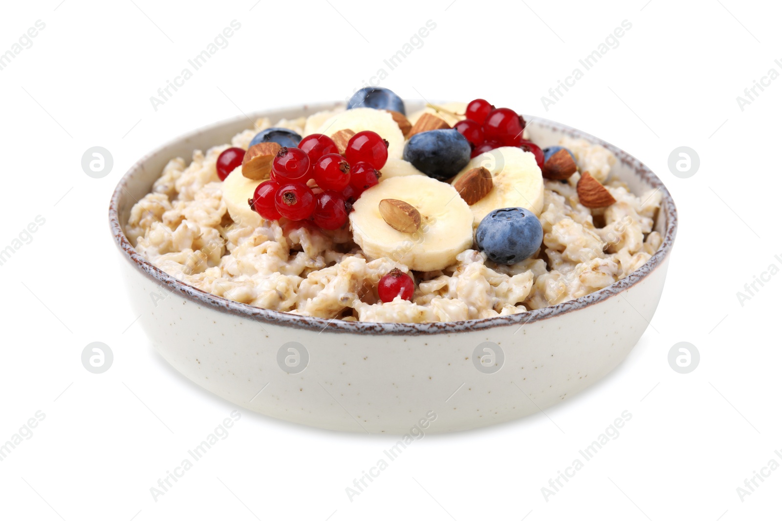 Photo of Ceramic bowl with oatmeal, berries and banana slices isolated on white