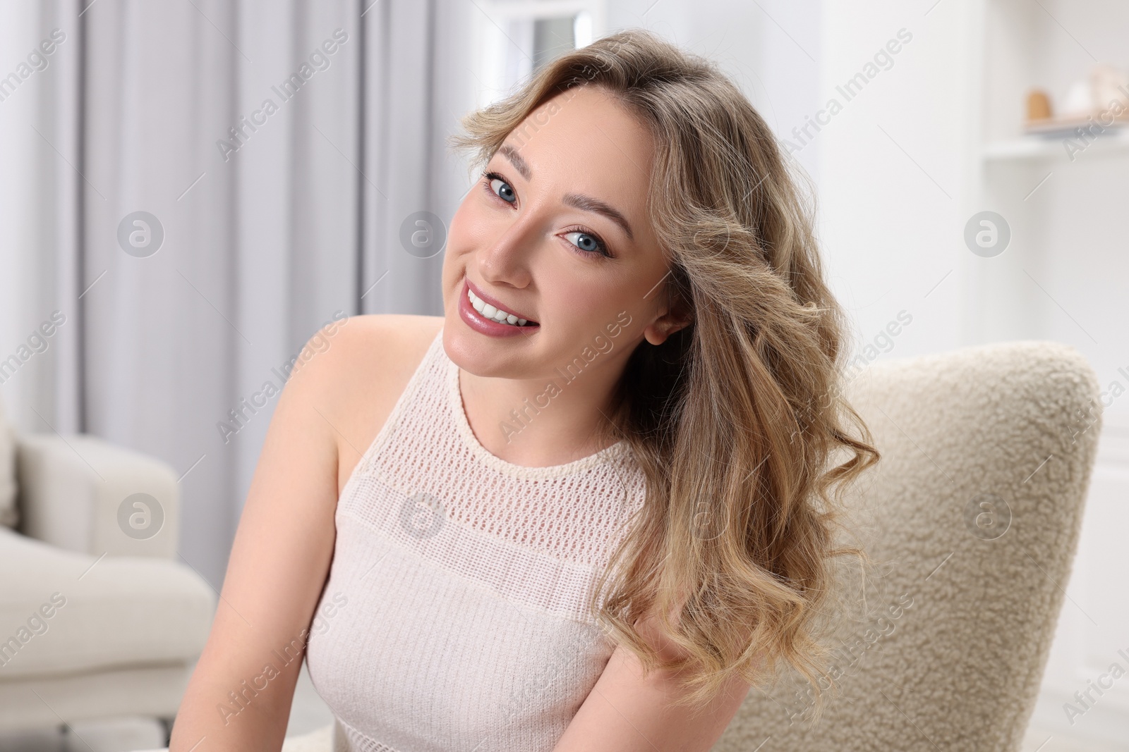 Photo of Portrait of smiling woman with curly hair at home