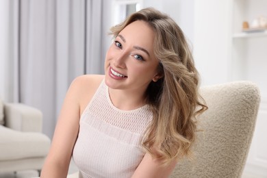 Photo of Portrait of smiling woman with curly hair at home