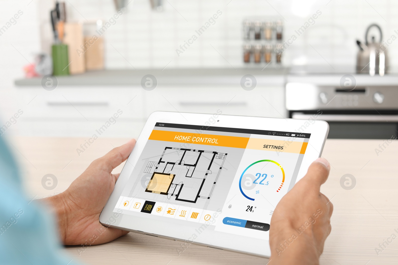 Image of Energy efficiency home control system. Man using tablet to set indoor temperature, closeup