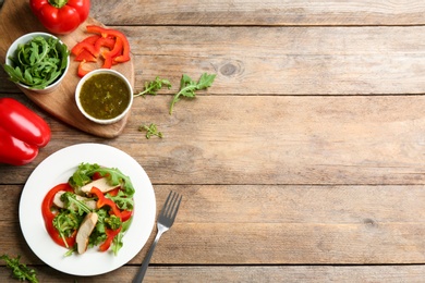 Photo of Delicious fresh chicken salad served on wooden table, flat lay. Space for text