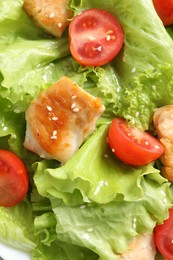 Delicious salad with chicken and cherry tomato as background, top view