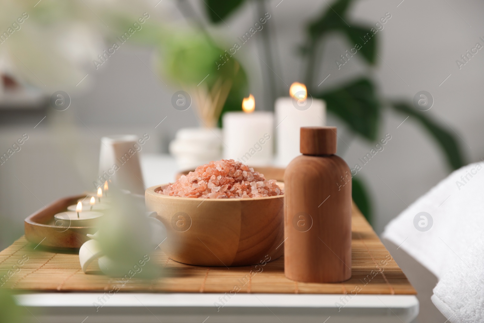 Photo of Cosmetic products and candles on table in spa salon, space for text