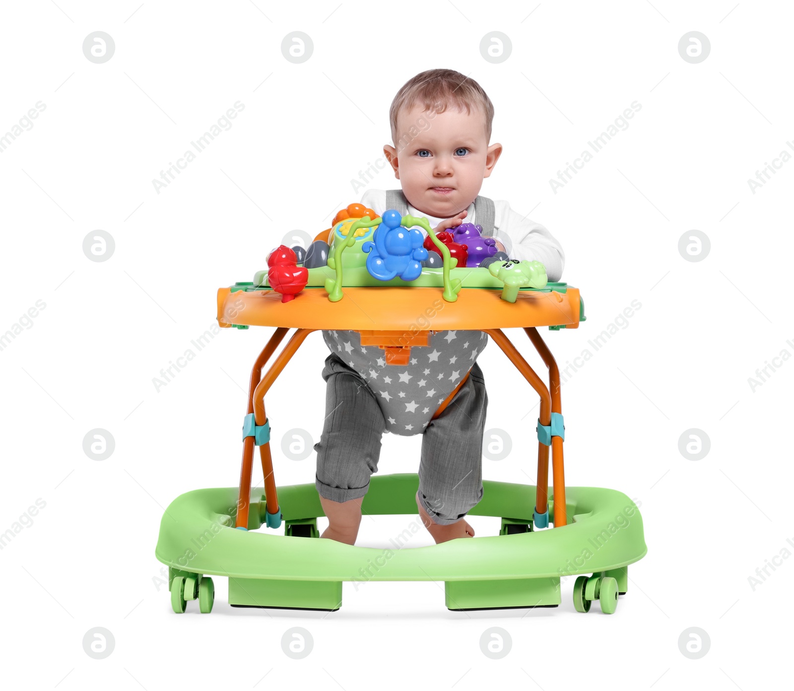 Photo of Cute little boy making first steps with baby walker on white background