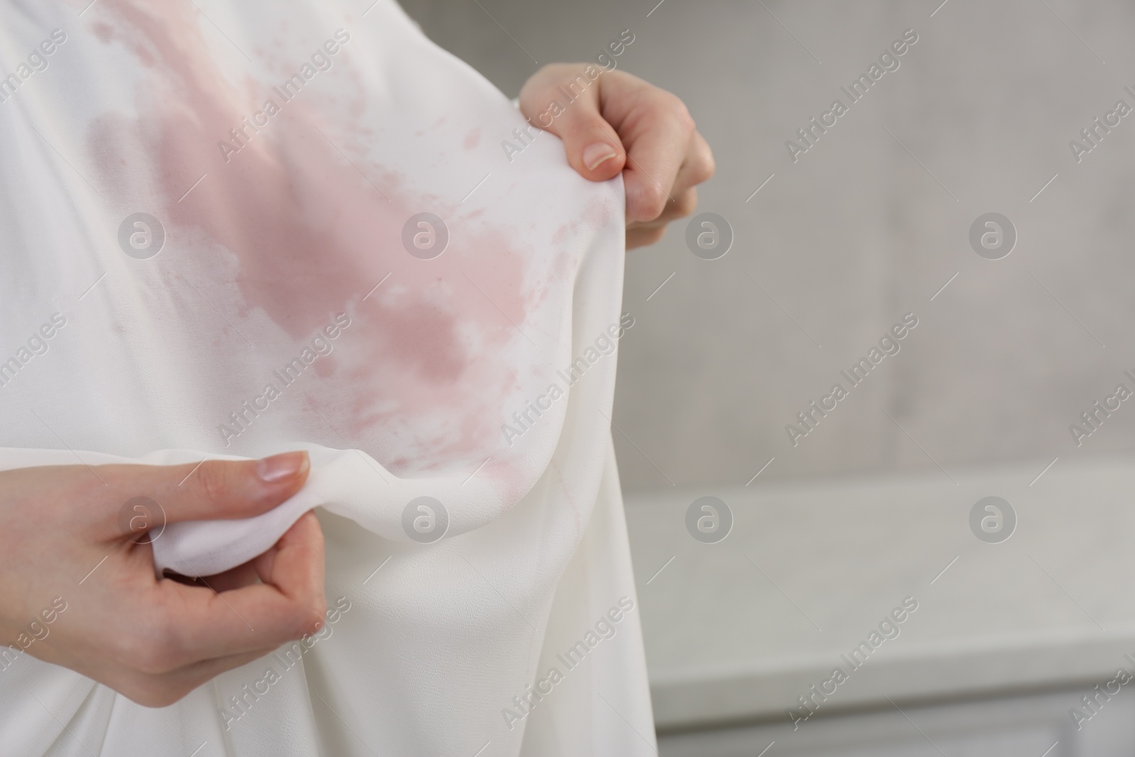 Photo of Woman with wine stain on her clothes indoors, closeup. Space for text