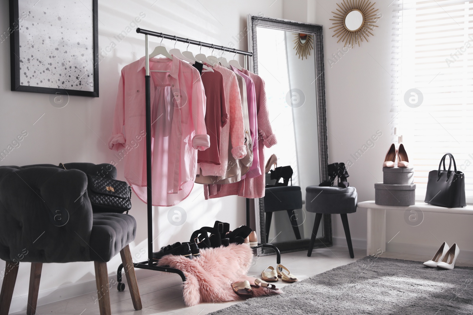 Photo of Dressing room interior with clothing rack and comfortable chair