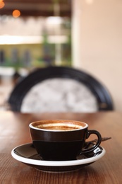 Cup of fresh aromatic coffee on table