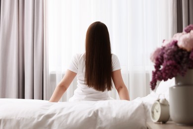 Photo of Woman on bed at home, back view. Lazy morning