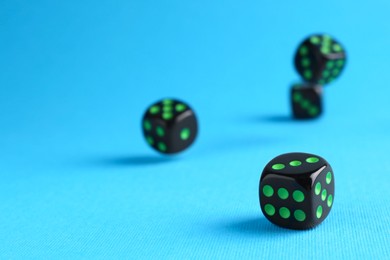 Photo of Many black game dices on light blue background