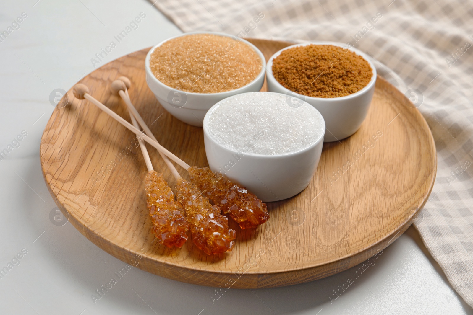 Photo of Board with different types of sugar on white table, closeup