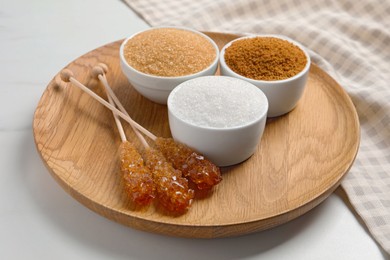 Board with different types of sugar on white table, closeup