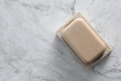 Photo of Soap bar on white marble table, top view. Space for text