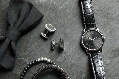Flat lay composition with luxury wrist watch on black background